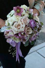 Beautiful Wedding Bouquet With Roses Ranunculus Hellebores Wax Flower Freesia Dusty Miller In A Purple Pea Purple Flower Bouquet Wax Flowers Coral Peonies