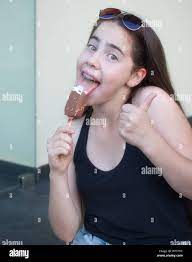 A 13 year old teenage girl with braces on her teeth giving a thumbs up  while celebrating the beginning of summer by leaking a va Stock Photo -  Alamy