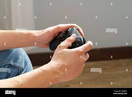 Mains de sexe masculin tenant le joystick de jeux vidéo de près Photo Stock  - Alamy