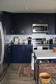 Two tone gray and white kitchen cabinets with black countertop. Navy Blue Cabinets Dark Kitchen Black Countertops Brass Hardware French Island Vint Black Kitchen Countertops Black Countertops Kitchen Black Counter
