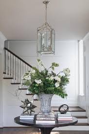 An Arch Lantern Hangs Over A Styled Round Black Wood Entry Table Round Foyer Table Foyer Table Decor Entrance Table Decor