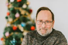 Portrait of Middle Age Man Posing Next To Christmas Tree Stock Image