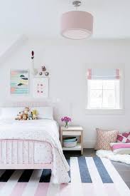Black And Pink Rug A Pink Drum Pendant Light Hangs Over A Pink And Black Striped Rug Complementing A Pink Metal Bed Dressed In White An Kid Room Decor Girl Room Little Girl Rooms