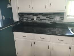 The current one is about 4 inches tall and appears to be glued to the countertop and the wall, then caulked along the seam between it and the countertop. Laminate Countertop Tile Backsplash Installation Nau Construction Inc