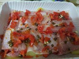 Sopra sistemare i filetti di cernia e fare un'altro strato di pomodori, capperi ed erbe aromatiche Filetto Di Cernia Al Forno Con Patate Al Gratin