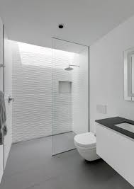 This primary bathroom boasts white tiles walls, white freestanding tub and a white pedestal sink. Walk In Showers Without Doors Or Curtains Design Tips And Examples Archdaily