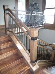 Rustic staircase with wrought iron baluster and railing, wood steps and surrounded by a stone block wall. Wood Iron Baluster Combinations Titan Architectural Products Of Utah