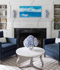Blue living room with a large framed artwork and tufted chairs accompanied by glass top tables. The Top 37 Blue Living Room Ideas Interior Home And Design