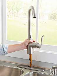 After turning off the water supply, remove the sink by taking apart the pipes, cutting the caulk, and undoing the sink's clamps. How To Install A Touchless Kitchen Faucet Better Homes Gardens