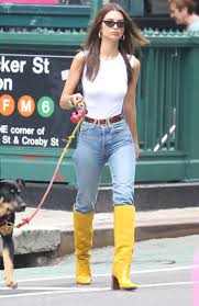 A red car was visible behind her, and she was striding across the pavement. Emily Ratajkowski In Jeans And Yellow Boots Walking Her Dog 18 Gotceleb