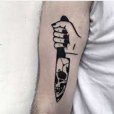 Hand Holding A Knife With A Skull Reflection On A Blade Tattooed On The Forearm By Ignacio Ttd Knife Tattoo Blade Tattoo Body Art Tattoos