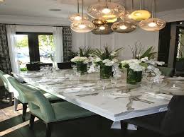 The long floral centerpiece with white candles looks spectacular and suits this long dining table. Best Dining Room Table Centerpieces Dimasummit Com