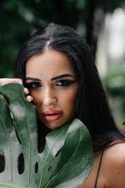 Una joven y bella morena posando entre densos matorrales de selva y selva. 