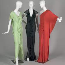 Vintage halston black jersey bias cut evening gown with asymmetrical beaded panels, low neckline, deep v at back, long sleeves, and slit. Vintage Style 1970s Fashion Designers