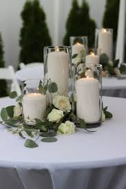 Glass Cylinders Filled With Candles And Surrounded By Greenery And Roses Romantic Wedding Centerpieces White Wedding Decorations Candle Wedding Centerpieces