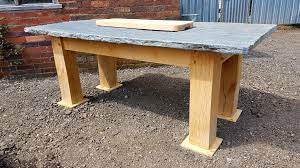 This dining table sits on four straight, slightly splayed block legs and has a rectangular tabletop with rounded edges designed to break up the look of straight lines. Oak And Slate Dining Table Ely Rustic Furniture