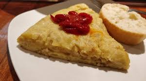 Tortilla de patata con pimientos. Cremosa y rica, acompañada de unos  pimientos rojos riquísimos. Tenían más variedades pero me decanté por la  clásica. Seguro que gana puntos recién hecha. - Picture of