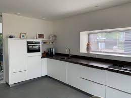 moderne semi greeploze keuken met witte fronten en koperkleurig werkblad hoekkeuken keukentrends tijdloze keuken keuken keuken trends