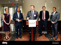 Navidea Biopharmaceuticals CEO Mark Pykett, speaks prior to the ribbon  cutting ceremony as Susan Windham-Bannister, President & CEO, Massachusetts  Life Sciences, left, Massachusetts Governor Deval Patrick, second left,  State Senator Barry Finegold (