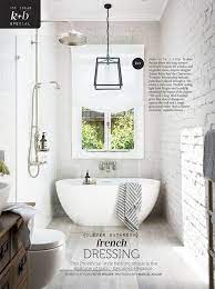 A contemporary bathroom doen with white brick walls, dark furniture, a shower, a vanity with a sink and an arched ceiling. Exposed Brick Bathroom Wall Small Chimney Toilets Subway Tiles Sinks Living Rooms Accent Walls Floo Brick Tiles Bathroom Brick Bathroom Bathroom Tile Designs