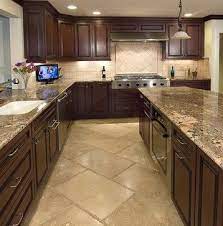 This kitchen is magnified by the dark golden cherry cabinets and a matching hardwood floor. Floor Kitchen Flooring Farmhouse Kitchen Cabinets Kitchen Remodel