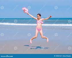 Young Happy Teen Girl Having Fun on Tropical Beach and Jumping in Pink  Swimsuit and Striped Hat into the Air on the Sea Coast Stock Photo - Image  of coast, leisure: 150034128