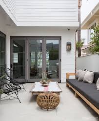 Modern Organic Outdoor Seating Area With Acapulco Chairs And Sofa With Wood Rattan And Black And Whi Outdoor Seating Areas Amber Interiors Beach House Decor