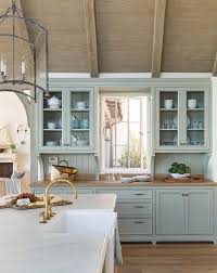 This kitchen features a thick wooden countertop placed on top of a metal kitchen island with lots of storage space included. Blue Cottage Kitchen Cabinets With Wood Countertop Cottage Kitchen