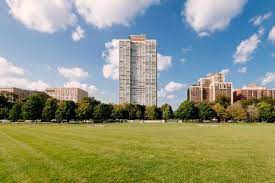 Green Grass Field Near City Buildings Under Blue Sky During Daytime Photo Free Grass Image On Unsplash Visit Chicago Photo City Buildings