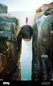 Nackte Frau auf Felsen verkeilt hoch über Wasser in Norwegen  Stockfotografie - Alamy