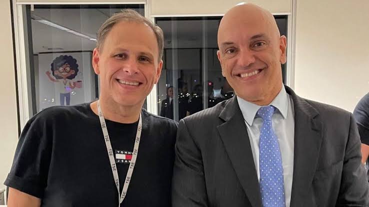 Foto de arquivo de Eduardo Tagliaferro sorrindo ao lado do ministro Alexandre de Moraes em ambiente institucional do TSE.