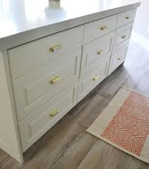 white kitchen island drawers with brass