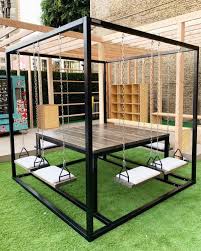 Black 8 Seater Swing Table With Oxidized Cedar By Swingtables Seen At Lululemon Glendale Swing Table Welded Furniture Backyard Decor