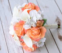 Along with the perfect wedding dress, the wedding flowers reflect the bride's style and the feeling of the day, whether it's there is no stress on the wedding day trying to keep fresh flowers hydrated. Natural Touch Off White Calla Lilies Coral Roses And Seashells Bouquet