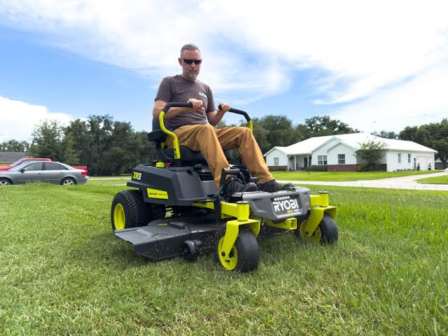 Ryobi battery-powered lawn mower operating on a residential lawn