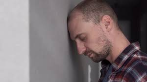 A Man Leans His Head Against A Wall.