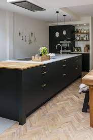 zwarte keuken met eiland voorzien van houten snijplank en wit composiet werkblad bekijk meer foto s op onze website keuken met eiland keuken keuken ontwerp