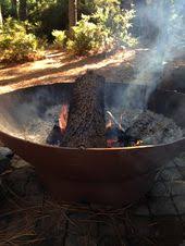A metal lid is provided to cover the burn area when not in use to convert the fire pit to a table. Propane Tank Fire Pit