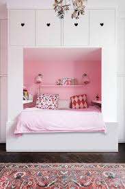 Charming pink and purple girl's bed room boasts a purple leather moroccan pouf placed on a purple and pink herringbone pattern rug layered beneath a white sheepskin rug. 4 Girls Bedroom Ideas Colours Dulux