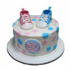 A beautiful shot of gender reveal party table with cake and blue and pink plate, fork and napkins. Gender Reveal Cake 3