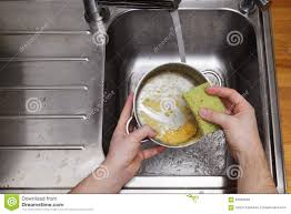 man washing dishes without gloves stock