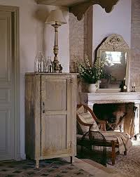 Sur La Cheminee En Pierre Charentaise Repose Un Trumeau Patine A L Ancienne Sur Le Profond Fauteui Cheminee En Pierre Deco Campagne A La Francaise Decoration