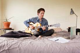 Maybe you would like to learn more about one of these? Man Playing Guitar On Bed Stock Photo Dissolve