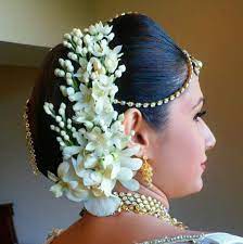 What A Beautiful Large Low Bun With Real Flower Gajra Juda Pin Care However Should Be Taken Before Adopting S Flowers In Hair Bridal Hairdo Bridal Hair Buns