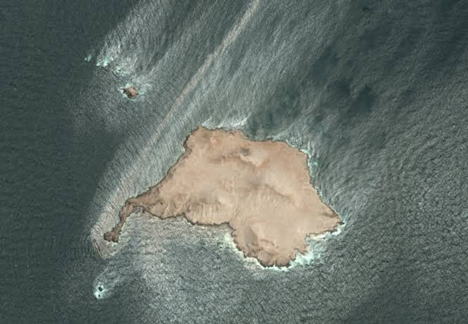 Satellite imagery showing a grounded oil tanker partially submerged in the waters off the coast of Oman.