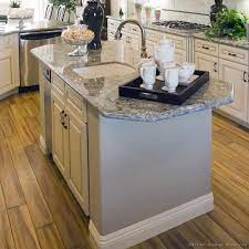 Neat and round in a compact room; Antique White Kitchen With Wood Floors And An Island Sink Kitchen Island With Sink Kitchen Island With Sink And Dishwasher Kitchen Island Plans