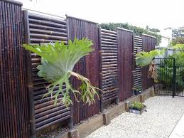Bamboos work as the material which builds up the panels of this backyard fence with the concrete blocks handle the base and the posts. Modern Fence Screening Ideas Privacy Screens Stained Bamboo Backyard Fence Ideas Fence Design Bamboo Screening Fence Bamboo Fence
