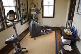 Small Nicely Designed Home Gym With Wood Floor And Large Exercise Mat With Elliptical Trainers And Side Tabl Workout Room Home Small Home Gyms Gym Room At Home