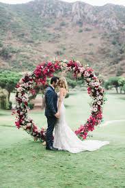 Add flowers and greenery, sprays and branches, crystal garlands, lighting and tulle to beautifully frame the moment while creating an ideal photo shoot backdrop! A Bold Fuchsia Blush And Hot Pink Floral Circle Wedding Arch With Leaves Tendencias Para Casamento Guirlanda De Casamento Casamento