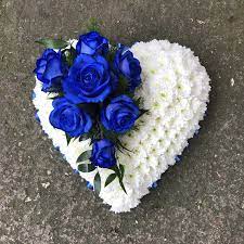 Blue and white flowers surround a clock urn. Blue Rose And White Heart Shaped Funeral Flowers Wreath Tribute Funeral Flowers Grave Flowers Flower Wreath